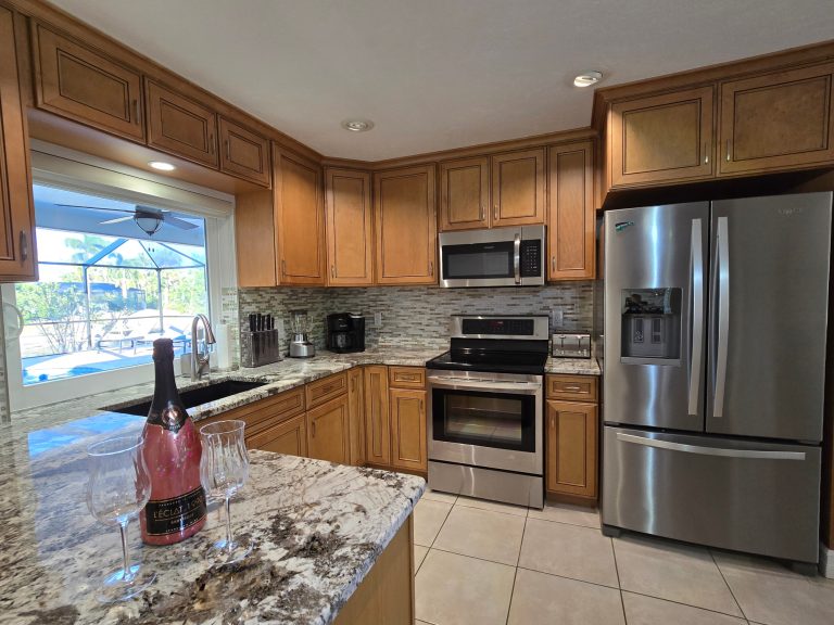 Moderne Küche mit Holzschränken, Granitoberfläche und Edelstahlgeräten.